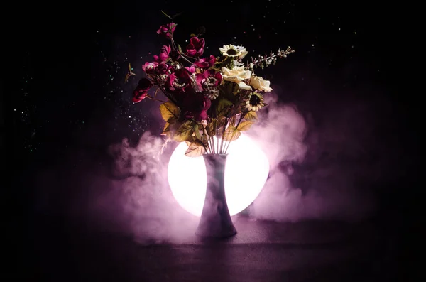 Malerische lila Frühlingsblumen in Glasvase, die in einer Reihe vor dunklem Hintergrund mit Sternen mit Licht und Nebel stehen. Nahaufnahme — Stockfoto