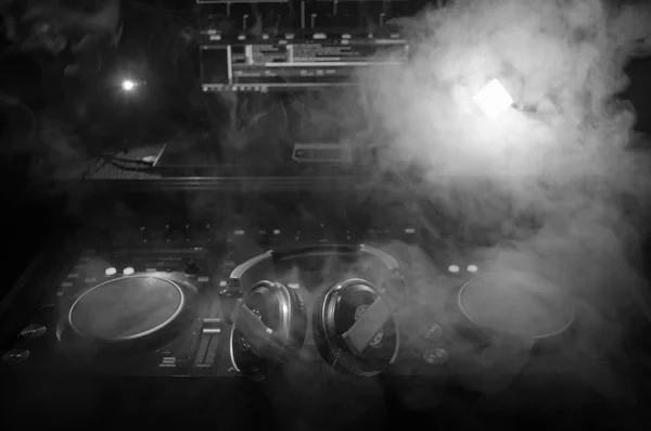 DJ Spinning, Mixing, and Scratching in a Night Club, Hands of dj tweak vari controlli delle tracce sul ponte del DJ, luci stroboscopiche e nebbia, messa a fuoco selettiva, da vicino. Concetto di vita del Dj Music club — Foto Stock