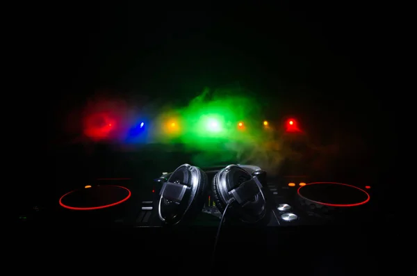 DJ spřádání, míchání a poškrábat v nočním klubu, ruce dj vylepšovat různé skladby ovládací prvky na dj deck, výstražná světla a mlha, selektivní fokus, zblízka. DJ Music club splácení — Stock fotografie