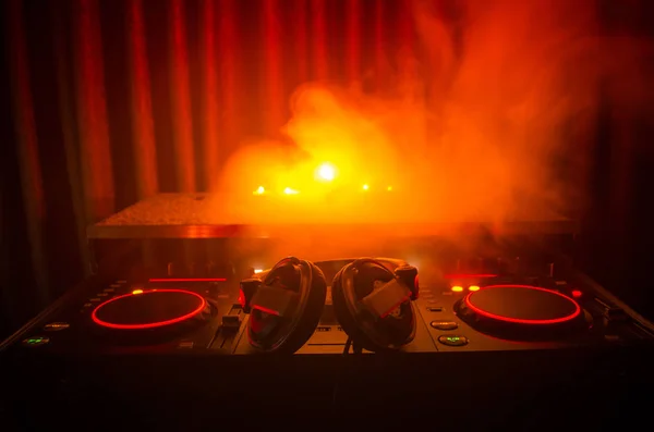 DJ Spinning, Mixing, and Scratching in a Night Club, Hands of dj tweak vari controlli delle tracce sul ponte del DJ, luci stroboscopiche e nebbia, messa a fuoco selettiva, da vicino. Concetto di vita del Dj Music club — Foto Stock