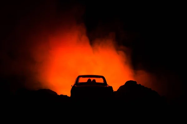 Silhueta de carro com casal dentro no fundo escuro com luzes e fumaça. Cena romântica. Conceito de amor — Fotografia de Stock