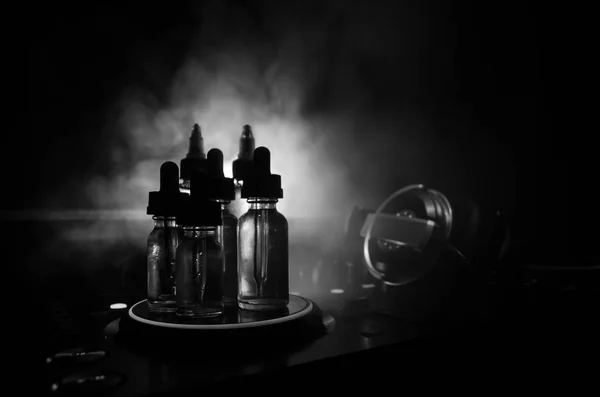 Conceito de Vape e DJ Club. Nuvens de fumaça e vape garrafas líquidas no misturador Dj de perto. Efeitos de luz. Útil como fundo ou vape ou clube propaganda ou fundo vape . — Fotografia de Stock