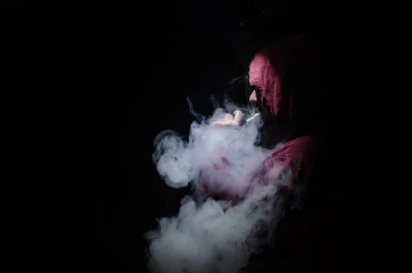 Vaping pria memegang mod. Awan Uap. Latar belakang hitam Menguap rokok elektronik dengan banyak asap — Stok Foto