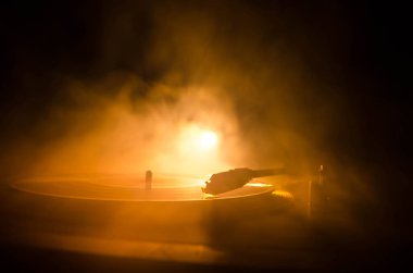 Pikap vinil plak çalar. Retro ses ekipmanları için disk jokey. Dj mix ve müzik çalmak için ses teknolojisi. Yangın arka plan duman ile yanan karşı oynanan vinil kaydı. Vintage