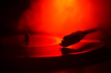 Pikap vinil plak çalar. Retro ses ekipmanları için disk jokey. Dj mix ve müzik çalmak için ses teknolojisi. Yangın arka plan duman ile yanan karşı oynanan vinil kaydı. Vintage