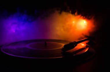 Pikap vinil plak çalar. Retro ses ekipmanları için disk jokey. Dj mix ve müzik çalmak için ses teknolojisi. Yangın arka plan duman ile yanan karşı oynanan vinil kaydı. Vintage