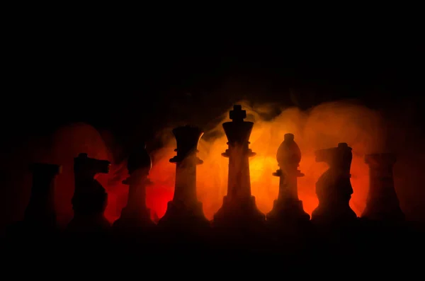 Tablero de ajedrez concepto de juego de ideas de negocios y la competencia y las ideas de estrategia cóncep. Figuras de ajedrez sobre un fondo oscuro con humo y niebla —  Fotos de Stock