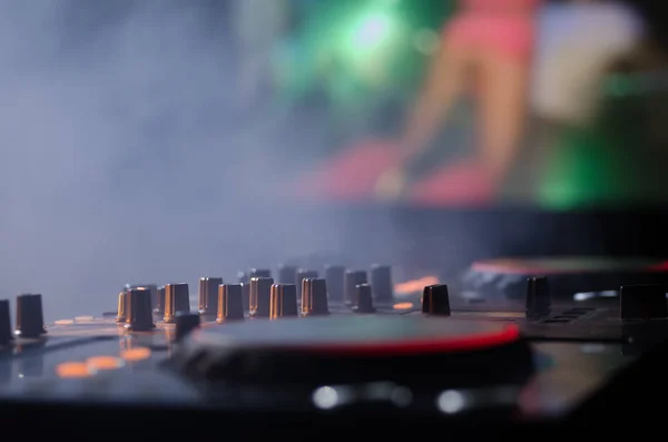 DJ Спінінг, Змішування та подряпини в нічному клубі, Руки діджеїв Твік різні елементи керування треком на палубі діджея, стробоскопічні вогні та туман, вибірковий фокус — стокове фото