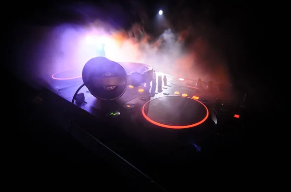DJ Спінінг, Змішування та подряпини в нічному клубі, Руки діджеїв Твік різні елементи керування треком на палубі діджея, стробоскопічні вогні та туман, вибірковий фокус — стокове фото
