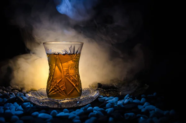 Tè azero turco in glasse tradizionale e pentola su sfondo nero con luci e fumo. Armudu tazza tradizionale — Foto Stock