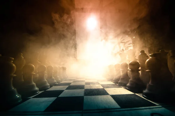 Chess board game concept of business ideas and competition and strategy ideas concep. Chess figures on a dark background with smoke and fog. Selective focus. Hand puts figure on board — Stock Photo, Image