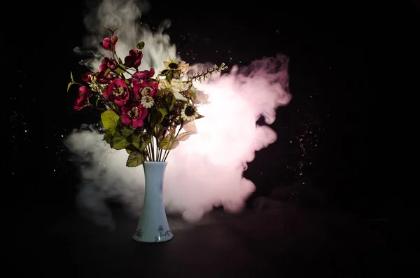 Pintorescas flores de primavera púrpura en jarrón de vidrio de pie en una fila sobre un fondo oscuro con estrellas con luz y niebla. De cerca. — Foto de Stock