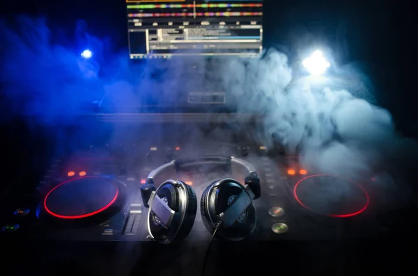 DJ spinnen, mixen en scratchen in een nachtclub, handen van dj tweak van de verschillende besturingselementen van het nummer op deck van de dj's, strobe lights en mist, selectieve aandacht, close-up. DJ Music club leven concept — Stockfoto