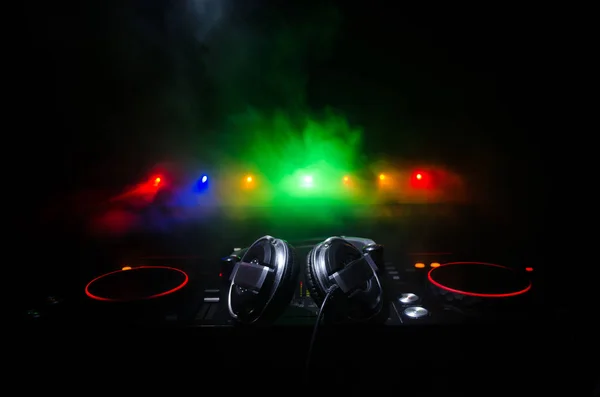DJ Spinning, Mixing, and Scratching in a Night Club, Hands of dj tweak various track controls on dj's deck, strobe lights and fog, selective focus, close up. Dj Music club life concept — Stock Photo, Image