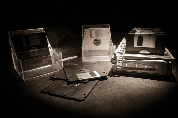 Pilha de disquetes pretos no fundo escuro com luz. Atributos de computador vintage — Fotografia de Stock