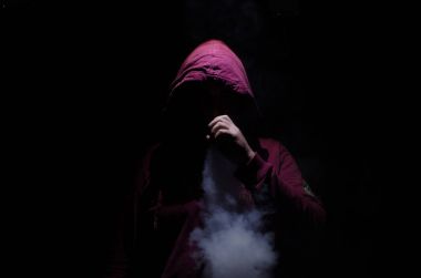 Bir mod tutarak Vaping adam. Buhar bulutu. Siyah arka plan. Vaping çok duman ile elektronik sigara