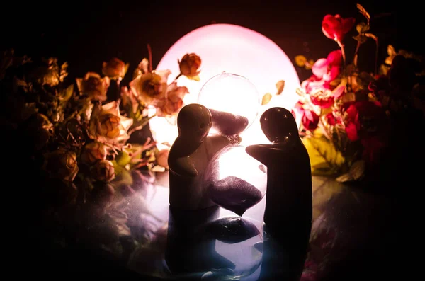 Dois abraços de boneca na mesa com flores e decoração da lua Fundo iluminado com smoke.Love conceito. Saudação ou ideia de design de cartão de presente. Tom vintage. Silhueta de casal abraçando — Fotografia de Stock