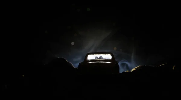 Siluett av bil med par inne på mörk bakgrund med ljus och rök. Romantisk scen. Kärlek-konceptet — Stockfoto