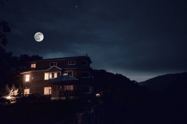 Güzel manzara Köyü binalar ve ağaçlar ve gece gökyüzüne büyük dolunay sokak. Büyük Caucasus .