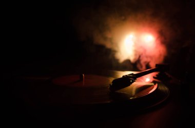 Pikap vinil plak çalar. Retro ses ekipmanları için disk jokey. Dj mix ve müzik çalmak için ses teknolojisi. Yangın arka plan duman ile yanan karşı oynanan vinil kaydı. Vintage