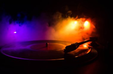 Pikap vinil plak çalar. Retro ses ekipmanları için disk jokey. Dj mix ve müzik çalmak için ses teknolojisi. Yangın arka plan duman ile yanan karşı oynanan vinil kaydı. Vintage