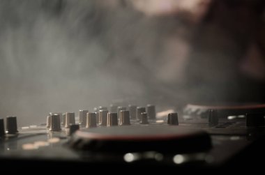 DJ iplik, karıştırma ve bir gece kulübünde tırmalamak, eller DJ 's dj güverte, strobe ışıklar ve sis, seçici odak çeşitli parça denetimlere tweak