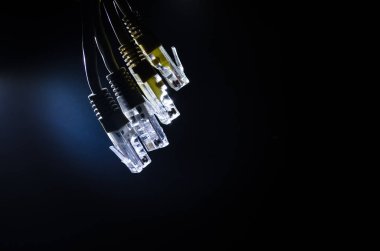 Ağ anahtarı ve ethernet kabloları, global iletişim sembolüdür. Işıklar ve duman ile koyu arka plan üzerinde renkli ağ kabloları. Seçici odak