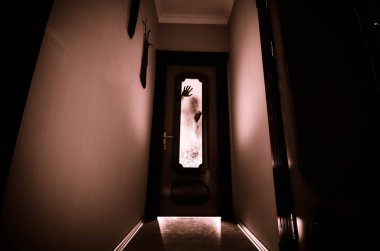 Bir bilinmeyen gölge figürü ile silüeti üzerinde kapalı cam kapı bir kapıdan eller. Korku kavramı