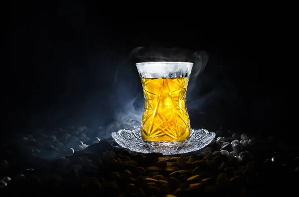 Turkish Azerbaijan tea in traditional glasse and pot on black background with lights and smoke. Armudu traditional cup — Stock Photo, Image