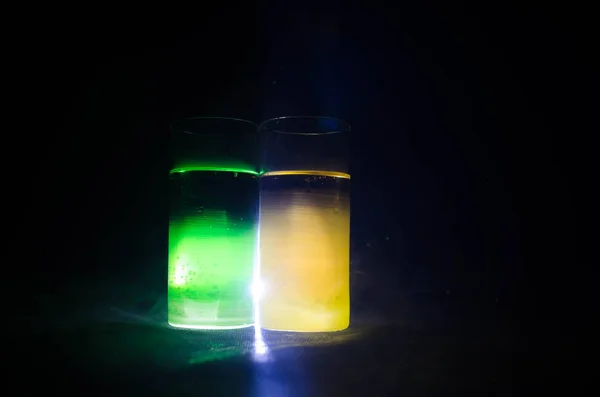 bright yellow green cocktail garnished with lime. Classic alcohol cocktails, alcoholic drinks, soft drinks, tasty cocktails on dark background with smoke and light