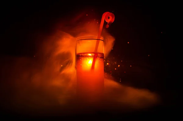 Üveg, piros alkoholos koktél a sötét háttérben a füst és a háttérvilágítás. A tűz forró koktél. Klub koncepció — Stock Fotó