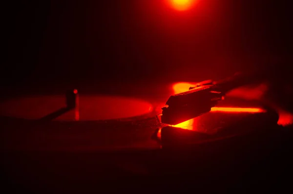 Tourne-disque vinyle. Équipement audio rétro pour disc jockey. Technologie sonore pour DJ pour mixer et jouer de la musique. Disque vinyle joué sur fond de feu brûlant avec de la fumée. Vintage — Photo