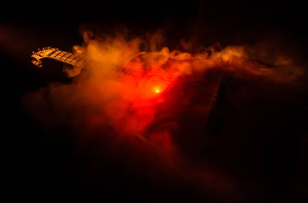 Conceito musical. Guitarra acústica isolada em fundo escuro sob feixe de luz com fumaça com espaço de cópia. Cordas de guitarra, de perto. Foco seletivo. Efeitos de fogo — Fotografia de Stock