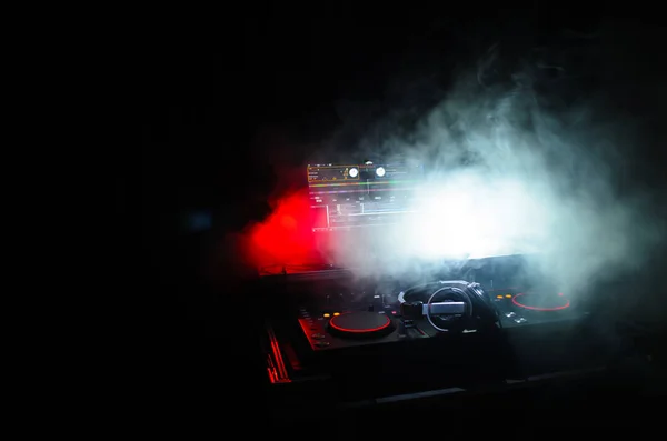 DJ Spinning, blandande och skrapa i en nattklubb, händerna på dj tweak olika spår kontrollerna på dj: s däck, strobe ljus och dimma, selektivt fokus, närbild. DJ Music club life concept — Stockfoto