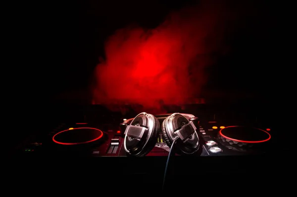 DJ Spinning, Mixing, and Scratching in a Night Club, Hands of dj tweak vari controlli delle tracce sul ponte del DJ, luci stroboscopiche e nebbia, messa a fuoco selettiva, da vicino. Concetto di vita del Dj Music club — Foto Stock