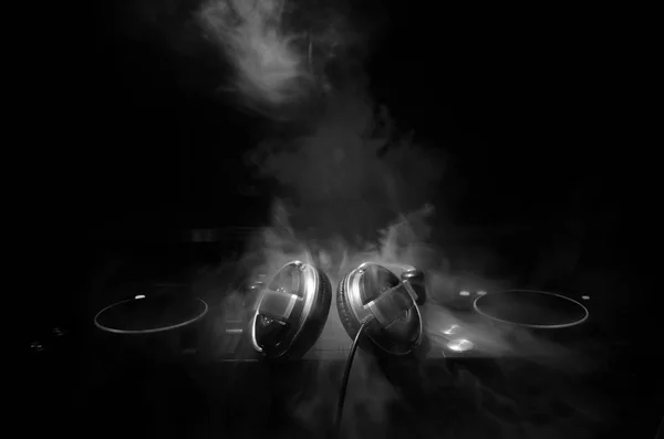 DJ Spinning, Mixing, e Scratching in a Night Club, Mãos de dj ajustar vários controles de pista no deck do dj, luzes estroboscópicas e nevoeiro, foco seletivo, close up. Dj Música conceito de vida clube — Fotografia de Stock