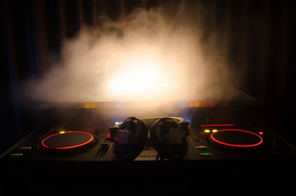 DJ Spinning, Mixing, and Scratching in a Night Club, Hands of dj tweak vari controlli delle tracce sul ponte del DJ, luci stroboscopiche e nebbia, messa a fuoco selettiva, da vicino. Concetto di vita del Dj Music club — Foto Stock