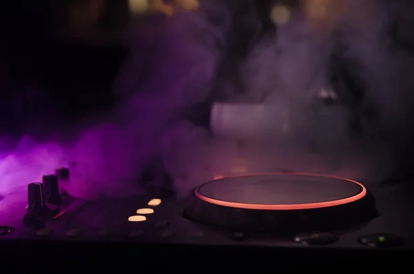 DJ Spinning, Mixing, and Scratching in a Night Club, Hands of dj tweak various track controls on dj's deck, strobe lights and fog, selective focus — Stock Photo, Image