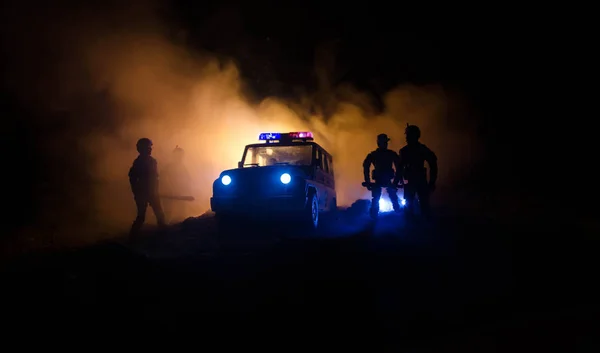 La policía antidisturbios da la señal de estar listo. Concepto de poder gubernamental. Policía en acción. Fuma sobre un fondo oscuro con luces. Sirenas azules rojas intermitentes. Poder de la dictadura. Enfoque selectivo — Foto de Stock