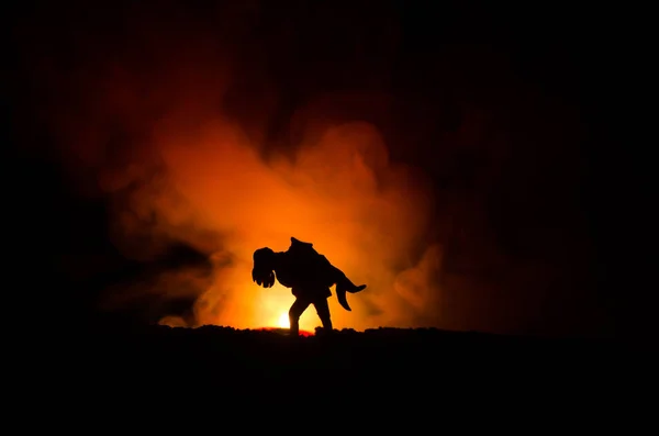 Una silueta de un hombre aferrado a la mujer. Concepto de rescate salvador. Escapar del fuego o el peligro. Reloj de arena, Fuego — Foto de Stock