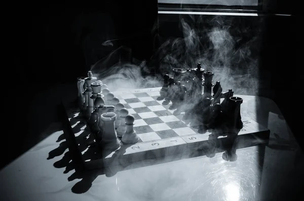 Chess board game concept of business ideas and competition and strategy ideas concep. Chess figures on a dark background with smoke and fog. Selective focus. Hand puts figure on board — Stock Photo, Image