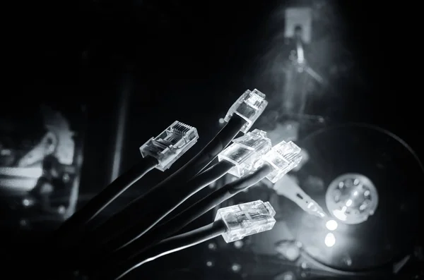 Interruptor de rede e cabos ethernet, símbolo de comunicações globais. Cabos de rede coloridos sobre fundo escuro com luzes e fumaça. Foco seletivo — Fotografia de Stock