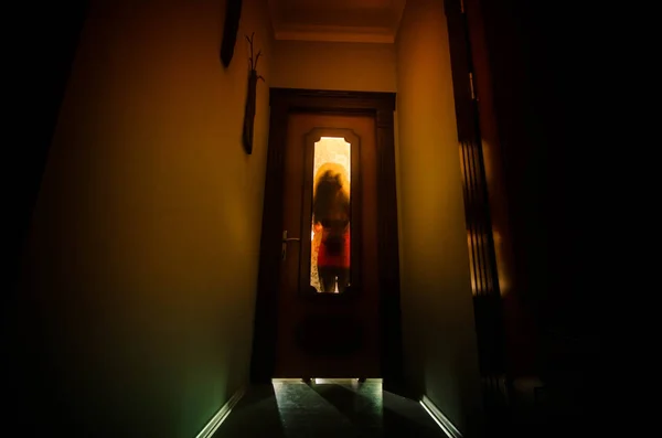 Bir bilinmeyen gölge figürü ile silüeti üzerinde kapalı cam kapı bir kapıdan eller. Korku kavramı — Stok fotoğraf