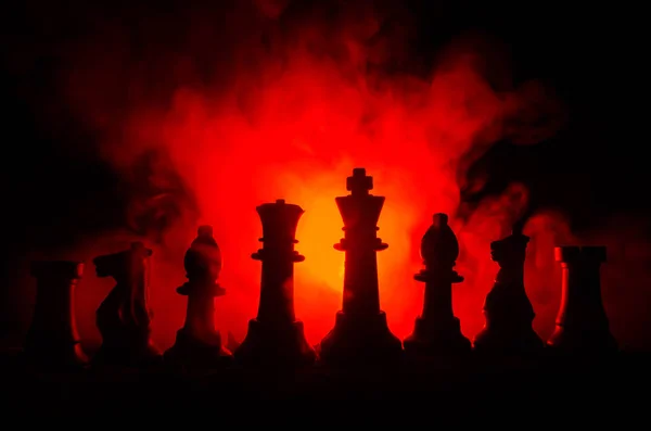 Chess board game concept of business ideas and competition and strategy ideas concep. Chess figures on a dark background with smoke and fog — Stock Photo, Image