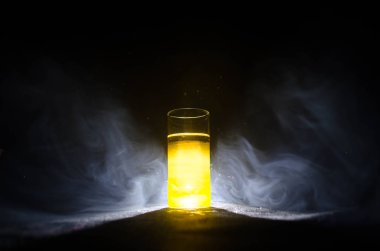 Kireç ile süslenmiş parlak sarı yeşil kokteyl. Klasik alkol kokteyller, alkolsüz içecekler, alkolsüz içecekler, duman ve ışık ile karanlık arka plan üzerinde lezzetli kokteyller