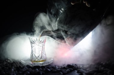 Geleneksel glasse ve ışıklar ve duman siyah zemin üzerine pot Türk Azerbaycan tea. Armudu geleneksel Kupası