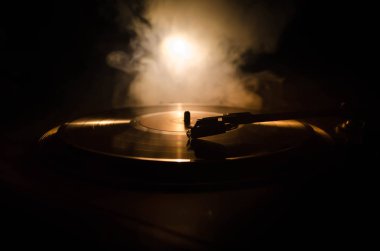Pikap vinil plak çalar. Retro ses ekipmanları için disk jokey. Dj mix ve müzik çalmak için ses teknolojisi. Yangın arka plan duman ile yanan karşı oynanan vinil kaydı. Vintage