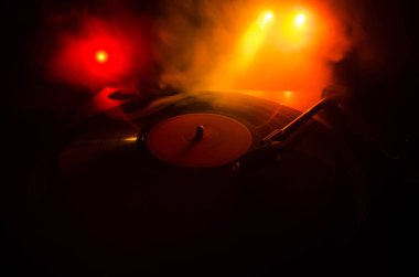 Pikap vinil plak çalar. Retro ses ekipmanları için disk jokey. Dj mix ve müzik çalmak için ses teknolojisi. Yangın arka plan duman ile yanan karşı oynanan vinil kaydı. Vintage