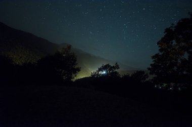 Dağ yolu ormandaki bir dolunay gecesi. Moon ile koyu mavi gökyüzünün doğal gece manzarası. Azerbaycan. Uzun çekim fotoğraf