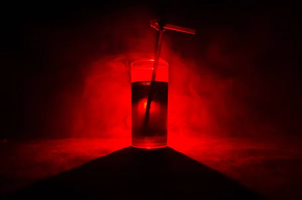 ガラスの赤アルコール カクテル煙とバックライトで暗い背景に。火災のホット カクテル。クラブのコンセプト — ストック写真